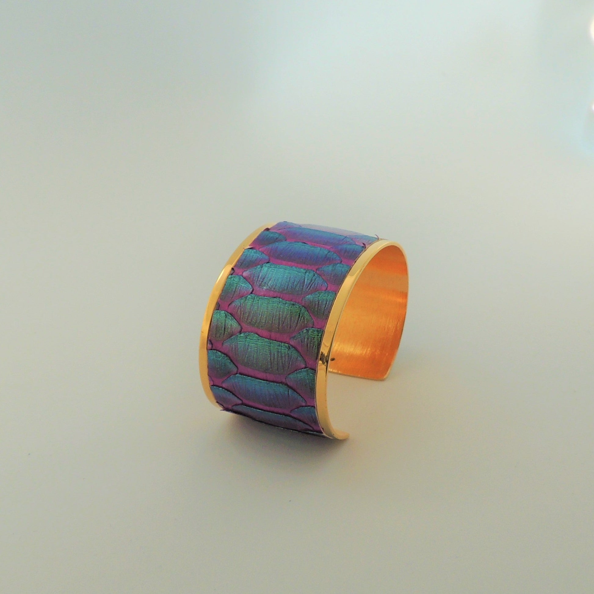 Brazalete de latón bañado en oro con acabado en piel de serpiente natural color magenta con escama grande