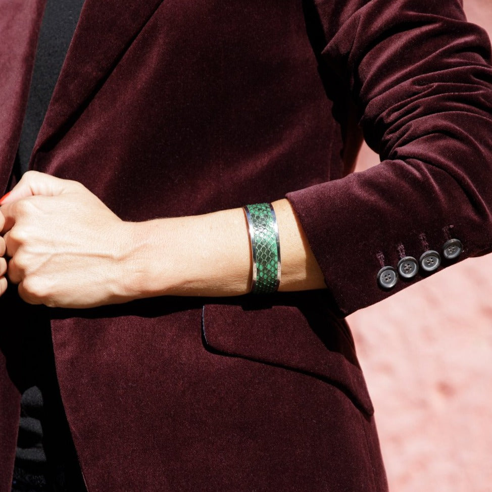 modelo con Pulsera de latón bañada en rodio con acabado en piel de pitón natural en varios color verde.